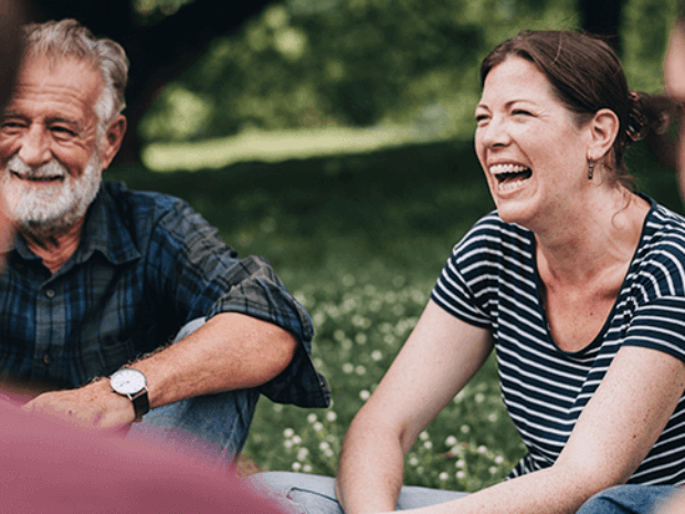 Foto von einer Gruppe Menschen, die zusammensitzen und lachen.