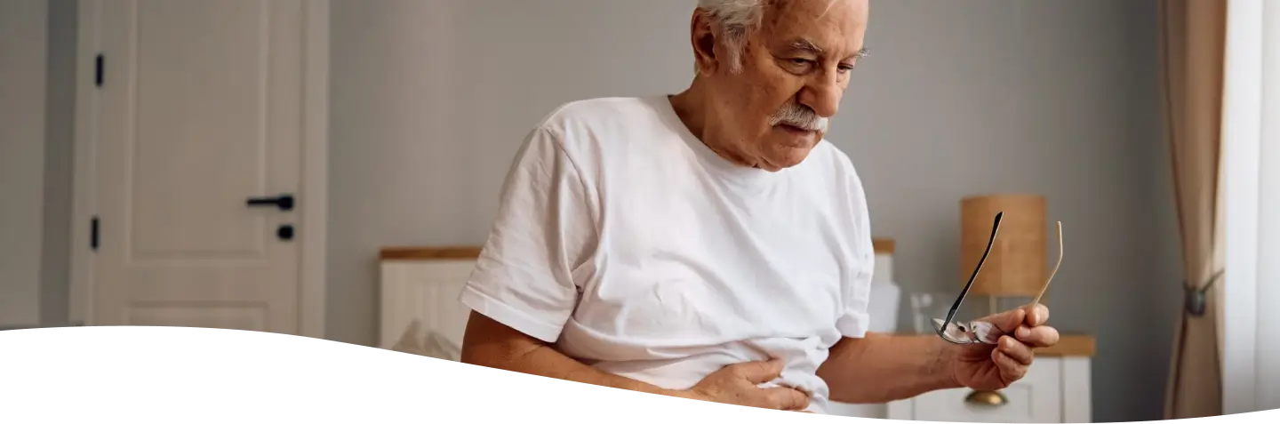 Mujer con camisa blanca dolorida por el dolor de panza