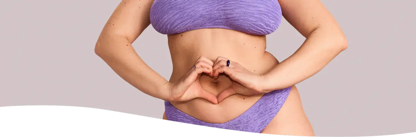 Mujer con camisa blanca dolorida por el dolor de panza