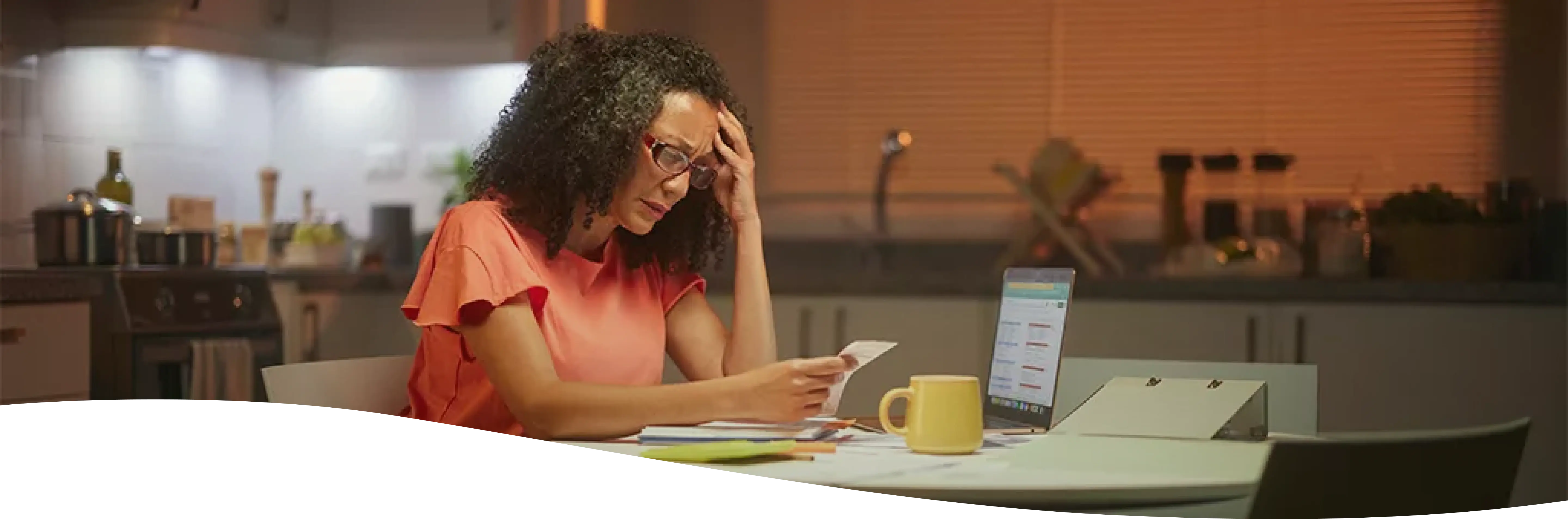 Mujer con rulos y anteojos agarrándose la cabeza mientras revisa cuentas